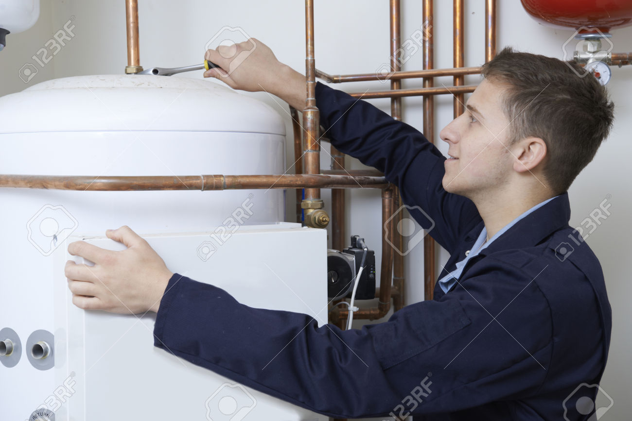 Male Plumber Working On Central Heating Boiler